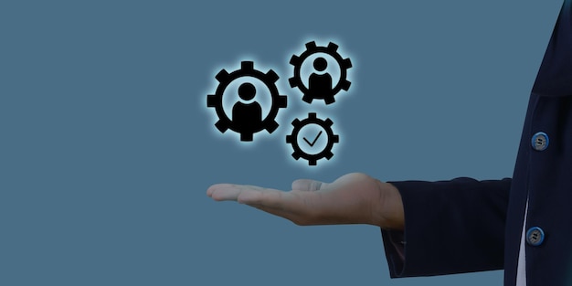 User and mechanical gears icon on the businessman hand with blue screen business concept