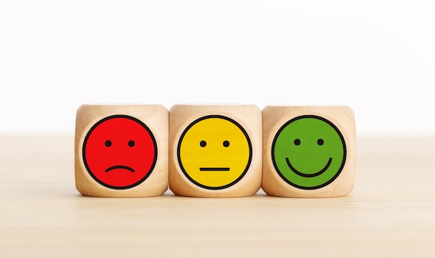 Photo user service feedback, rating customer review, poll, satisfaction survey concept. wooden blocks with facial expressions