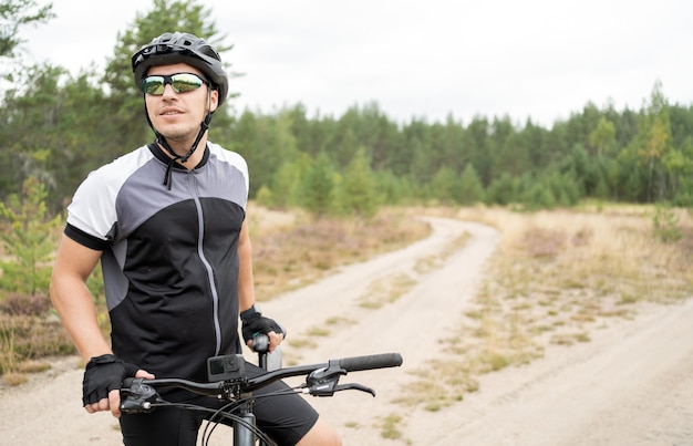 Uses a fitness watch a cyclist on a mountain bike in a helmet\
and equipment eco tourism