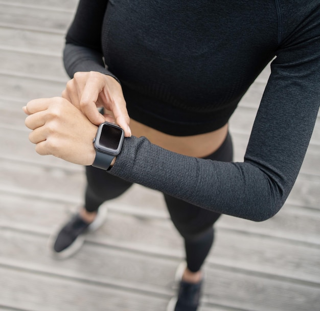 Uses a fitness watch on her arm a female athlete runs does an active workout on the street