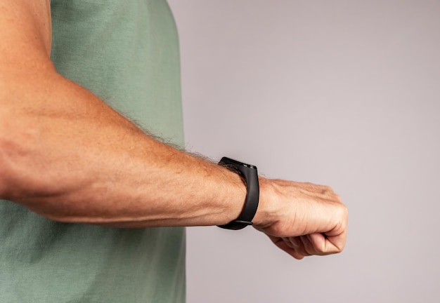 Using black smart fitness watch bracelet on men hand