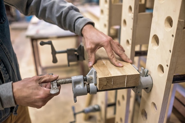 Фото Использование зажимов и клея для соединения деревянных брусьев для деталей мебели.