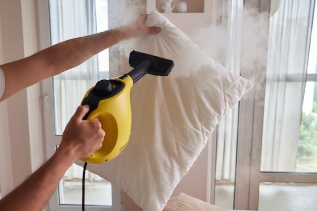 Premium Photo  Using dry steam cleaner to sanitize pillow