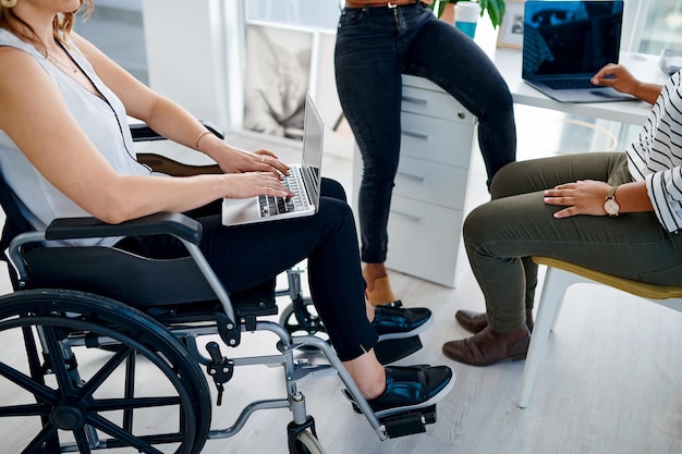 Using the internet to make informed decisions Shot of a businesswoman with disabilities sitting with colleagues in the office