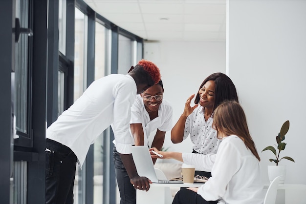 Utilizzo del laptop gruppo di uomini d'affari afroamericani che lavorano insieme in ufficio