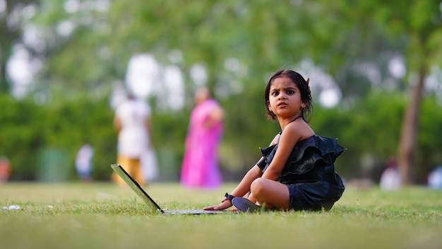 Using laptop little girl in the farm with angry face