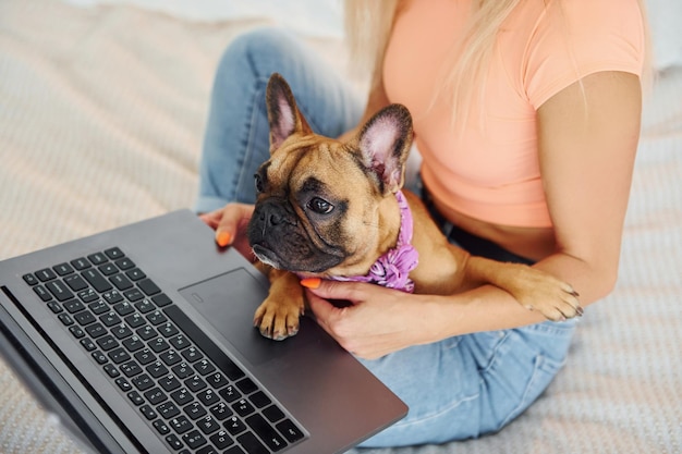 Photo using laptop woman with pug dog is at home at daytime