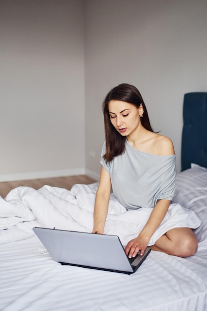 Using laptop Young woman resting and spending weekend at home alone at home