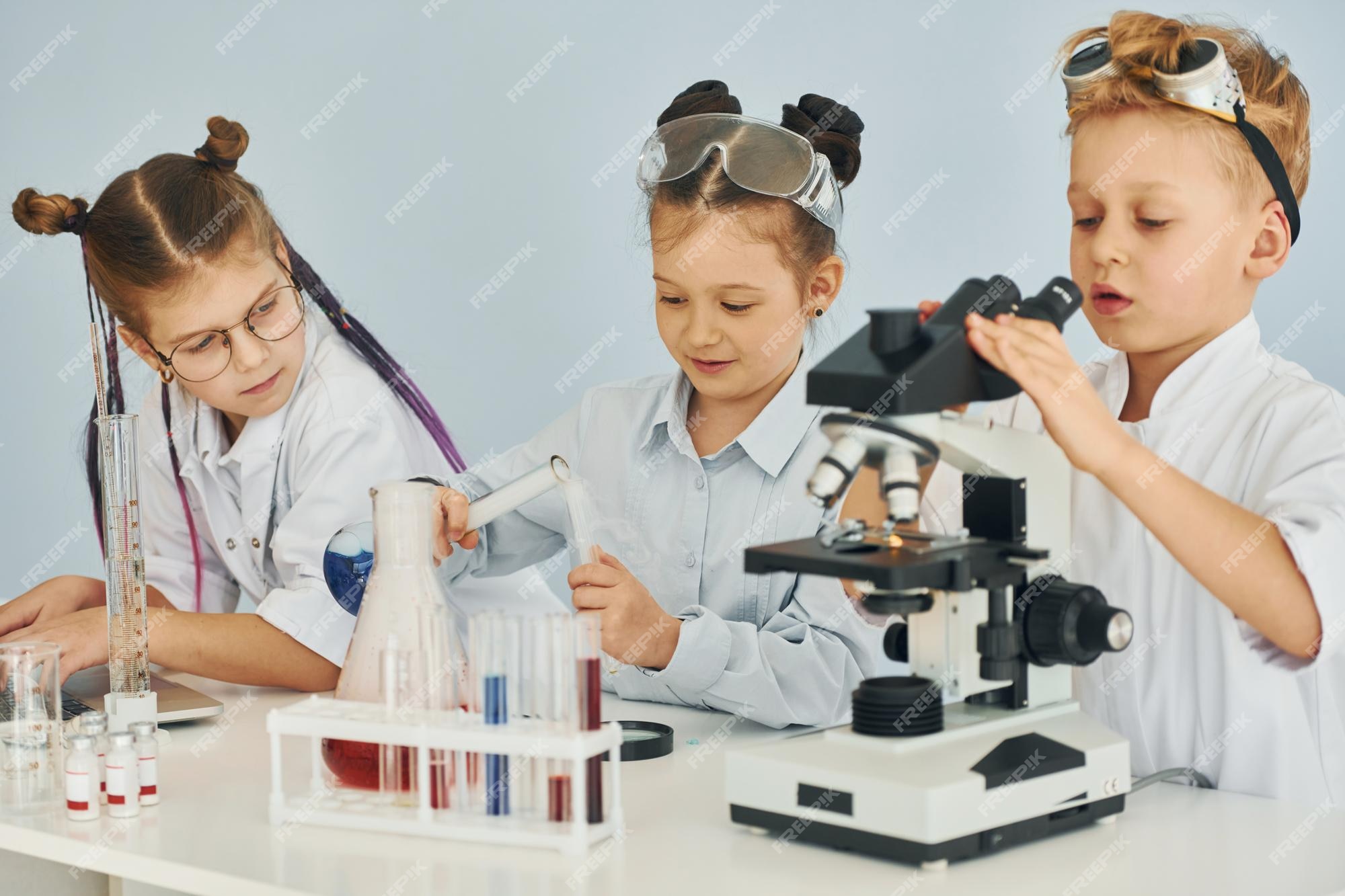 Two Young Characters With Science Club Equipment On White Background Male  And Female Teens Wearing White Coats And Smiling Set Of Scientific Items  With Microscope Science Book Tubes Formulas Stock Illustration 