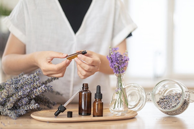 Foto usare l'olio essenziale naturale in un rituale spa domestico una donna si prende cura della sua pelle e dei suoi capelli