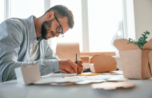 Foto usando la penna per disegnare un nuovo design stampa lavoratore domestico in abiti bianchi è al chiuso