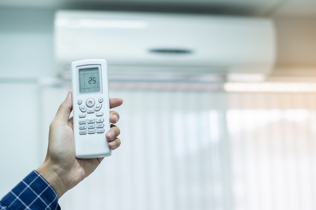 using remote controller for adjust Air conditioner inside the room of office or house