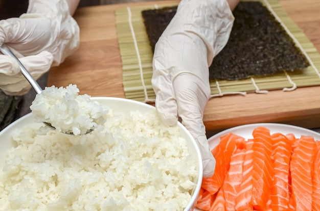Использование риса для суши, процесс приготовления суши с лососем и авокадо