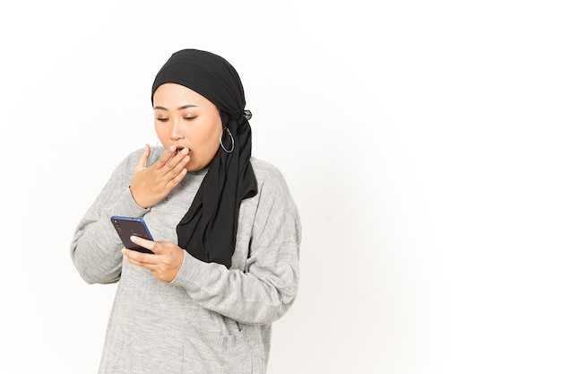 흰색 배경에 고립 된 히잡을 쓰고 아름 다운 아시아 여자의 스마트폰 사용