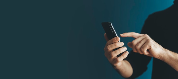 Using a smartphone by a young man on a blank background Phone in hand while using the Internet