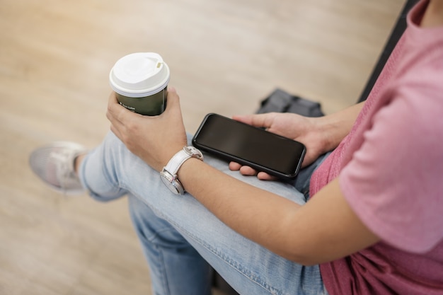 using smartphone between drinking hot coffee.