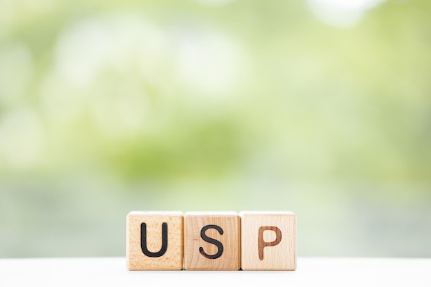 USP word is written on wooden cubes on a green summer background Closeup of wooden elements