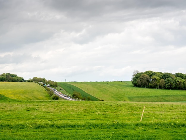 Обычный вид на сельское поле и облачное небо в Англии возле Стоунхенджа Солсбери