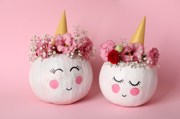 Сute pumpkins with halloween makeup on pink background