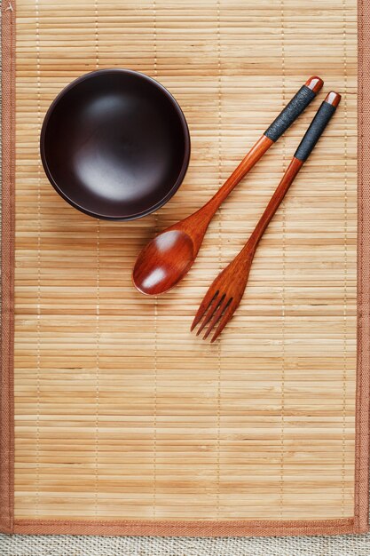 Utensils made of wood, bowl and spoons on a cutting board on a white background