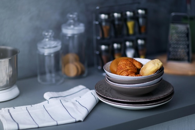 Utensils towel and croissants on modern kitchen table close up