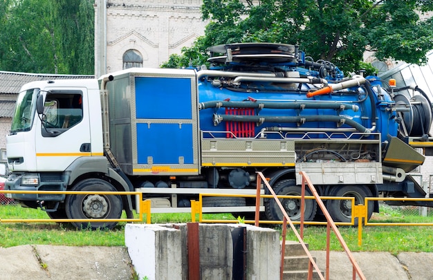 Фото Коммунальная машина для очистки городских сточных вод возле резервуара с городскими сточными водами