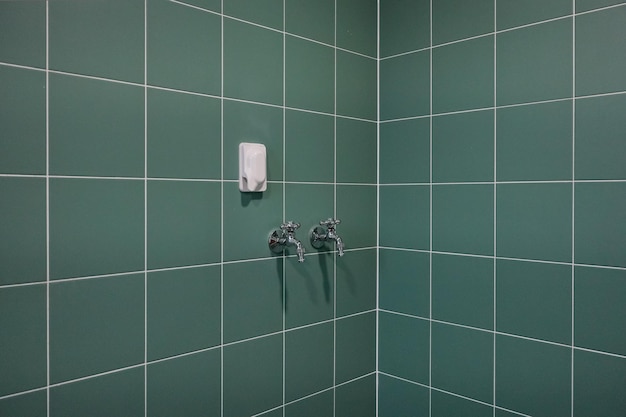 緑の四角いタイルと洗濯機専用水栓で仕上げたユーティリティルーム