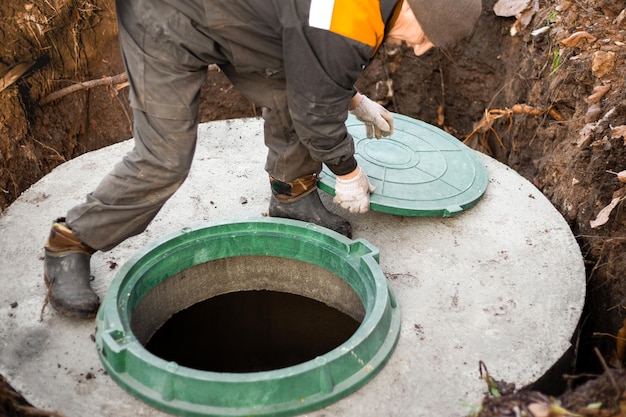 A utility worker opened a well hatch for sewerage maintenance and pumping out feces Septic on a residential lot