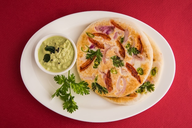 Uttapam or Oothappam is a dosa-like dish from South India served with sambar and chutney