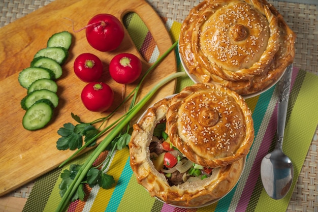 Uzbek cuisine samsa chorba decorated with green onion red radishes and sliced cucumber