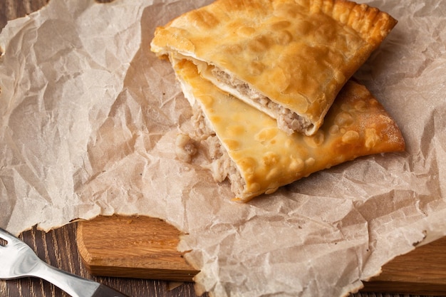 Uzbek eastern Tatar cuisine cheburek on a wooden board Cheburek fried pie with meat Traditional dish of Turkish and mongolianpasties empanada