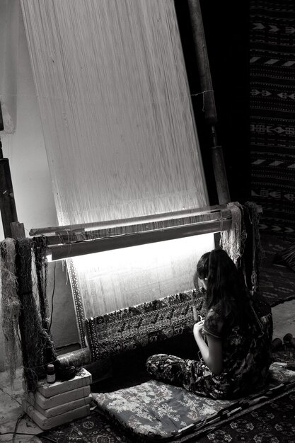 Uzbek girl weaving carpet, Bukhara, Uzbekistan. Black and white photo