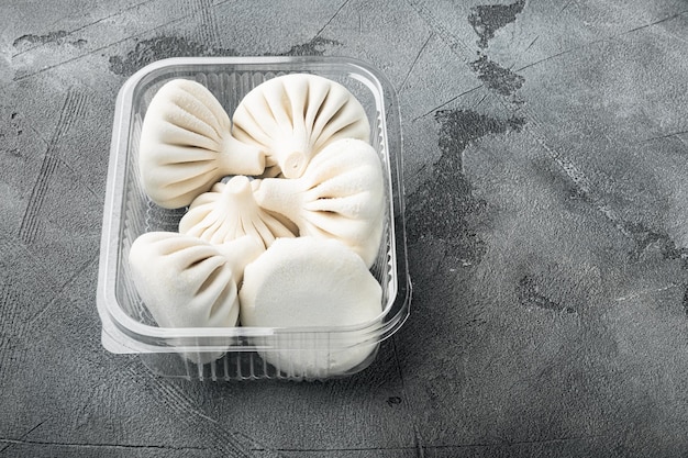 Uzbek Manti. Manti or manty dumplings, popular uzbek-asian dish set, in plastic tray, on gray stone background, with copy space for text