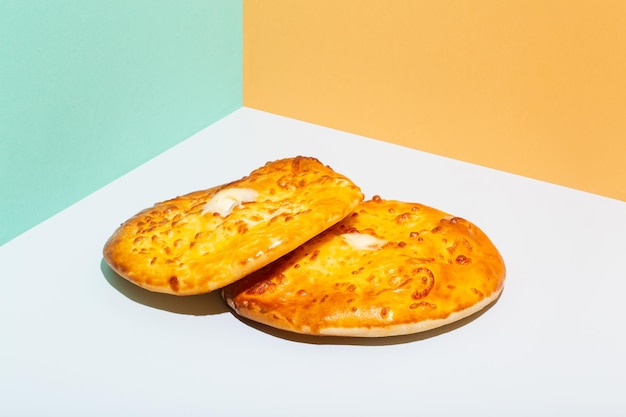 Uzbek national food tandyr bread lepeshka with cheese on blue background minimalistic style high qua...