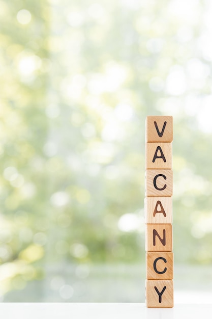 Vacancy word is made of wooden blocks lying on the table\
concept green background