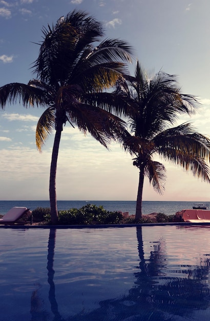 vacation, beach, summer and leisure concept - swimming pool on tropical beach