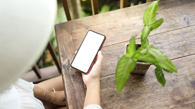 Vacation concept Woman hand holding black smartphone relax at hotel resort enjoying luxury lifestyle outdoor