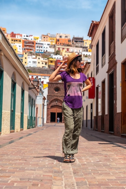 Vacation concept woman walking through the city of San Sebastian de la Gomera next to the Iglesia De La Asuncion Canary Islands