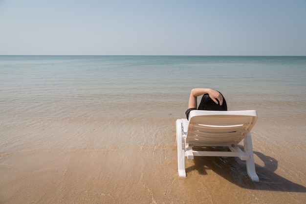 Фото Отдых на тропический пляж женщина отдохнуть на пляже кровать с чистой водой океана фон