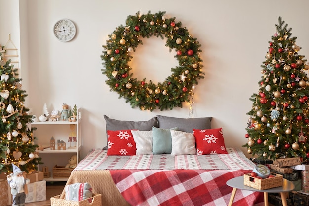 Vacation Rentals Interior apartment Christmas bedroom Bed against background of Christmas tree and wreath New Year's Eve celebration at home