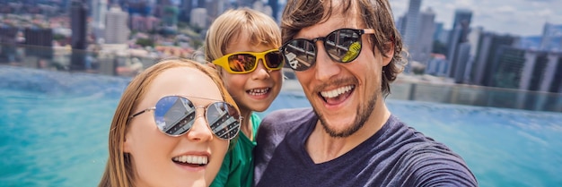 Vacation and technology happy family with kid taking selfie together near swimming pool with