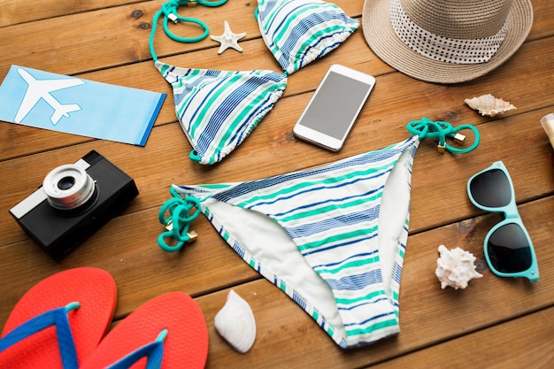 Foto concetto di vacanza, viaggio, turismo, tecnologia e oggetti - primo piano di smartphone e roba da spiaggia