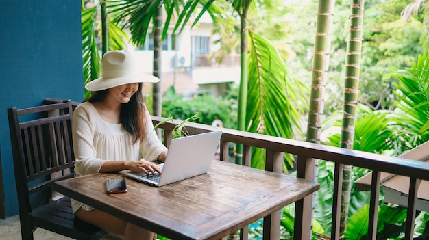 Concetto di tecnologia del computer portatile di viaggio di vacanza donna che lavora al suo laptop in vacanza
