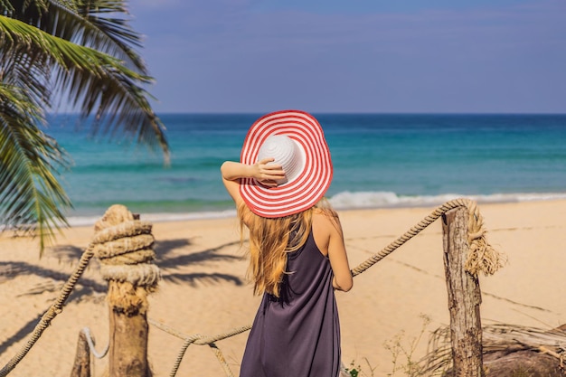 Vacation on tropical island Woman in hat enjoying sea view from wooden bridge