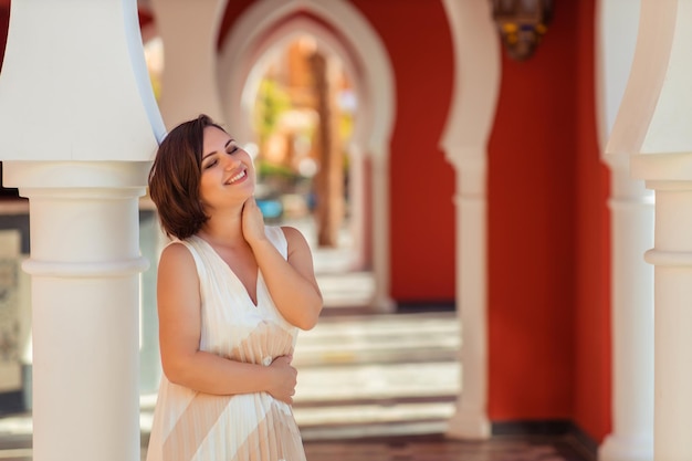 Отдых в теплом арабском. загородный портрет красивой улыбающейся женщины в длинном платье