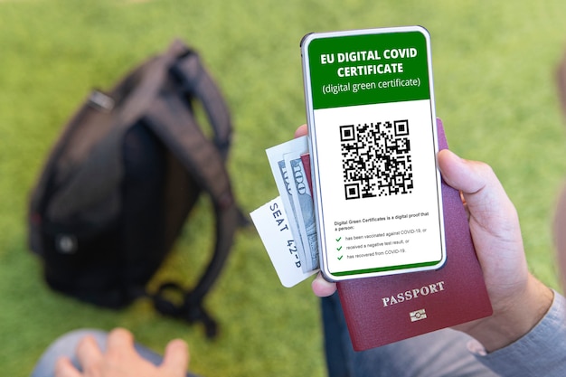 Вакцинированный человек использует приложение цифрового паспорта здоровья в мобильном телефоне для путешествий во время пандемии covid-19. зеленый сертификат. справка о подтверждении вакцинации и наличия антител