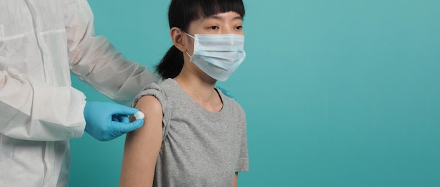 Vaccinatie immunisatie ziekte preventie concept. Vrouw met medisch gezichtsmasker die Covid 19 of griepvaccin krijgt. Arts die katoen voor en na maakt injectie gebruikt. Coronavirus gevaccineerde vrouw.