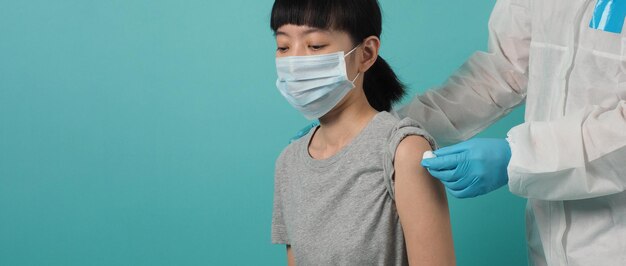 Vaccinatie immunisatie ziekte preventie concept. Vrouw met medisch gezichtsmasker die Covid 19 of griepvaccin krijgt. Arts die katoen voor en na maakt injectie gebruikt. Coronavirus gevaccineerde vrouw.