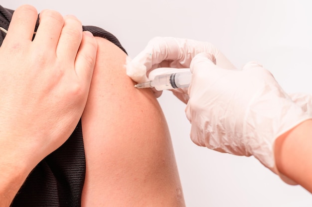 Vaccination close up injection of vaccine in hand doctor in white gloves