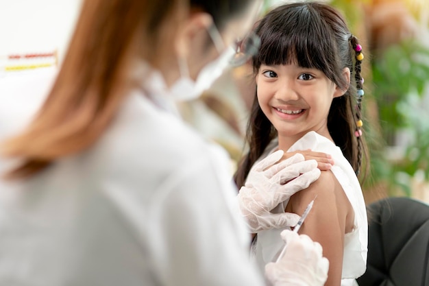 Photo vaccination concept female doctor vaccinating cute little girl in clinic